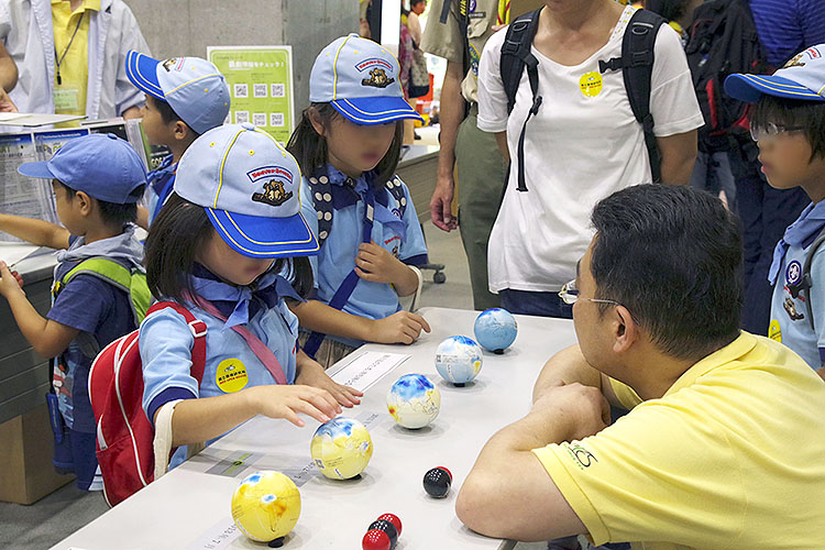 夏の大公開で、興味津々に手作り地球儀をさわる子供たち